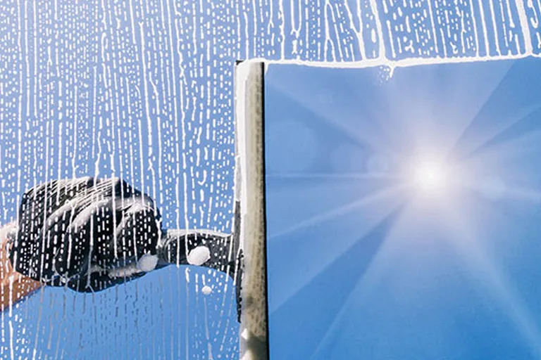 Fensterreinigung mit Abzieher an einer Glasfläche